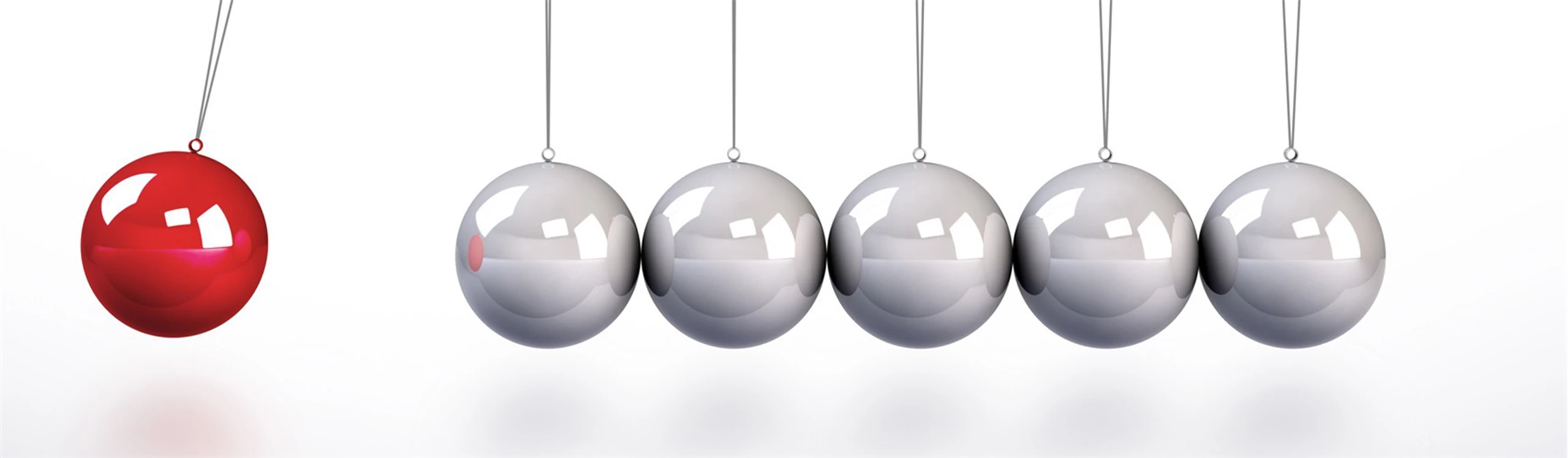 Newton-Pendel mit einer roten Kugeln schwingt von links gegen silberne Kugeln.