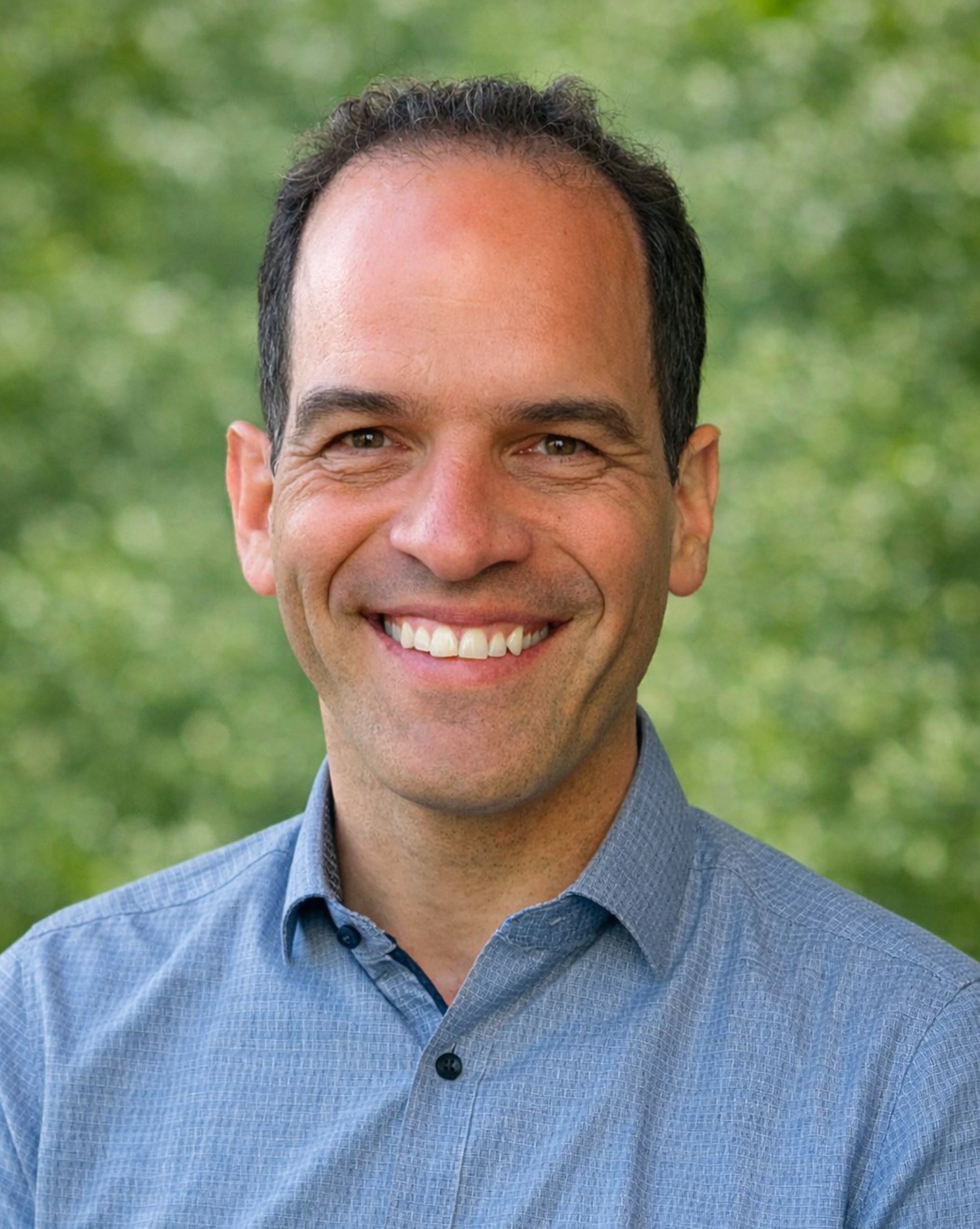 Porträtbild eines lächelnden Mannes im Karo-Hemd